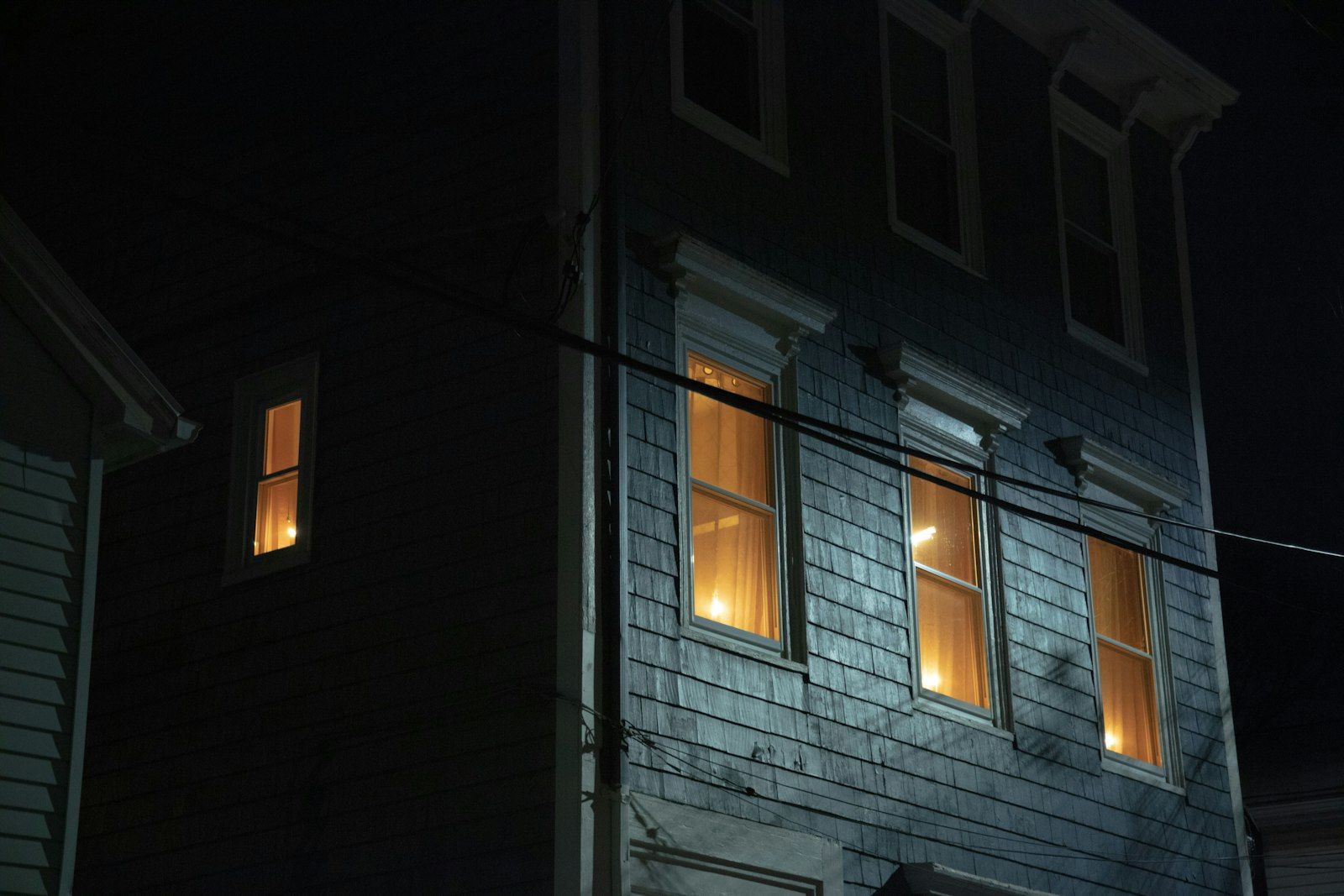 A house with two windows lit up at night